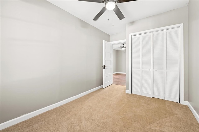 unfurnished bedroom with ceiling fan, a closet, and light carpet