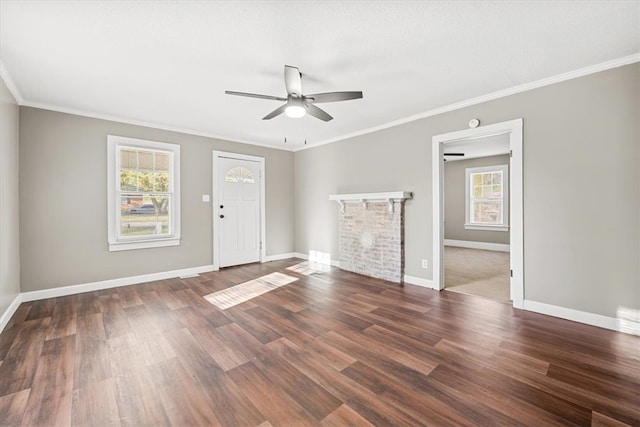 interior space with ceiling fan, dark hardwood / wood-style floors, crown molding, and a fireplace