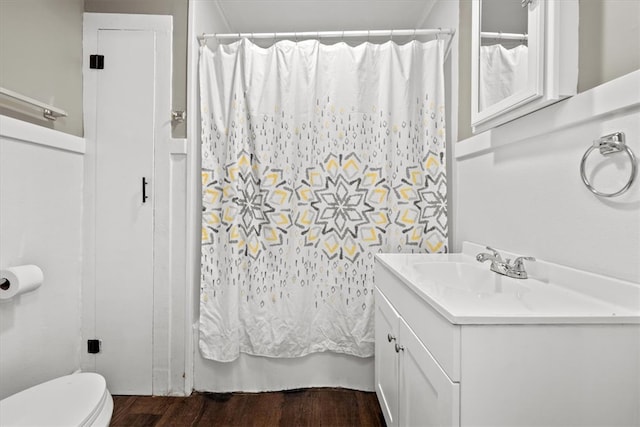 bathroom with wood-type flooring, vanity, toilet, and walk in shower