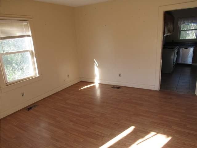 unfurnished room with a healthy amount of sunlight and wood-type flooring