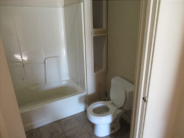 bathroom featuring tile patterned flooring, shower / bathing tub combination, and toilet