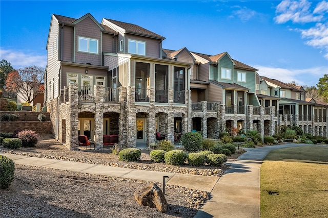 view of front of home with a sunroom and a balcony