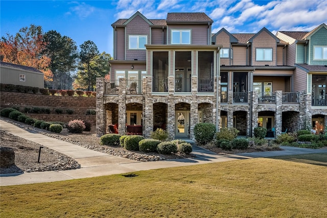 view of front of home with a front yard and a sunroom