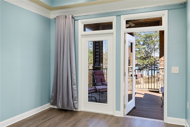 doorway with a healthy amount of sunlight, wood-type flooring, and crown molding