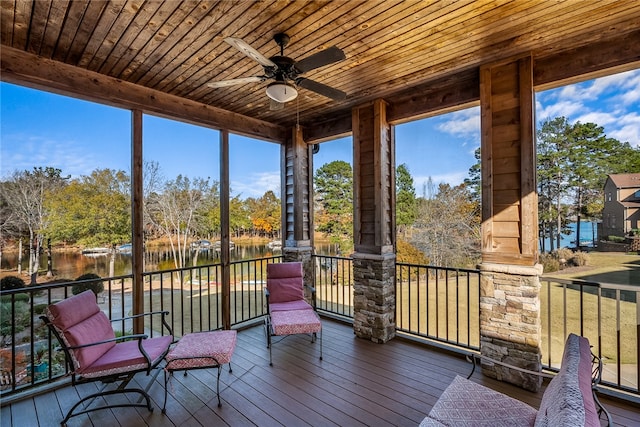 sunroom / solarium with ceiling fan, a water view, wood ceiling, and a wealth of natural light