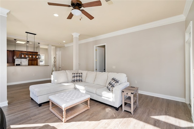 living room with wood-type flooring, ornate columns, ceiling fan, and crown molding