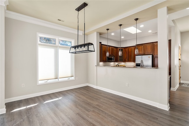 kitchen featuring kitchen peninsula, appliances with stainless steel finishes, dark hardwood / wood-style floors, and pendant lighting