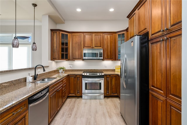 kitchen featuring crown molding, sink, stainless steel appliances, and light stone counters