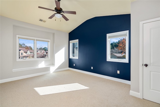 carpeted empty room with ceiling fan and vaulted ceiling