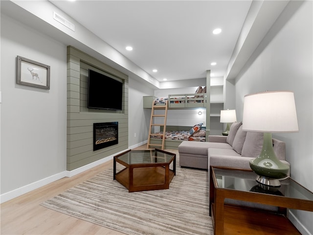 living room with light wood-type flooring and a large fireplace