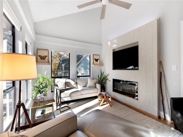 living room with a fireplace, ceiling fan, plenty of natural light, and high vaulted ceiling