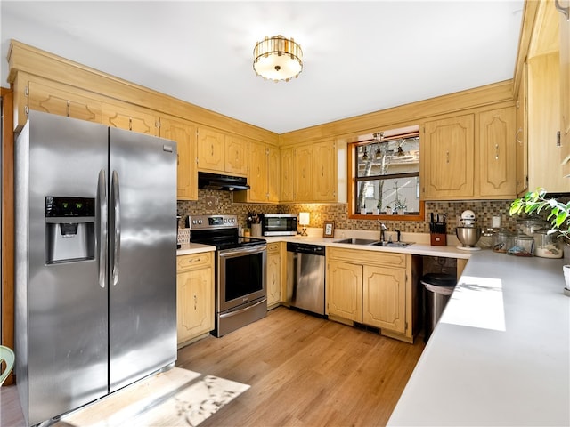 kitchen featuring backsplash, stainless steel appliances, light hardwood / wood-style flooring, and sink