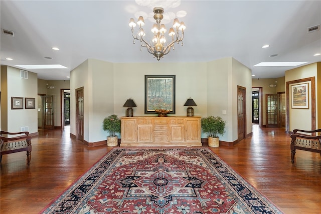 hallway with a notable chandelier, dark wood-type flooring, and a skylight