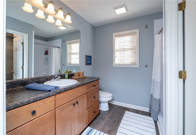 bathroom with hardwood / wood-style floors, vanity, and toilet