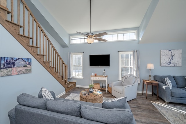 living room featuring a towering ceiling, dark hardwood / wood-style flooring, and ceiling fan