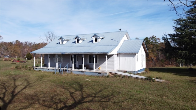 rear view of property featuring a yard and a porch