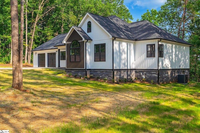 view of side of home featuring a lawn, cooling unit, and a garage