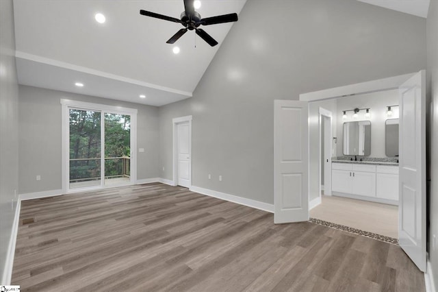 unfurnished living room featuring light wood-type flooring, high vaulted ceiling, and ceiling fan