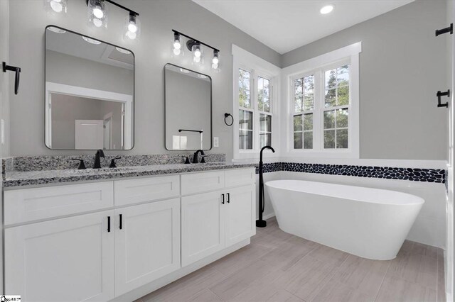 bathroom featuring a tub to relax in and vanity