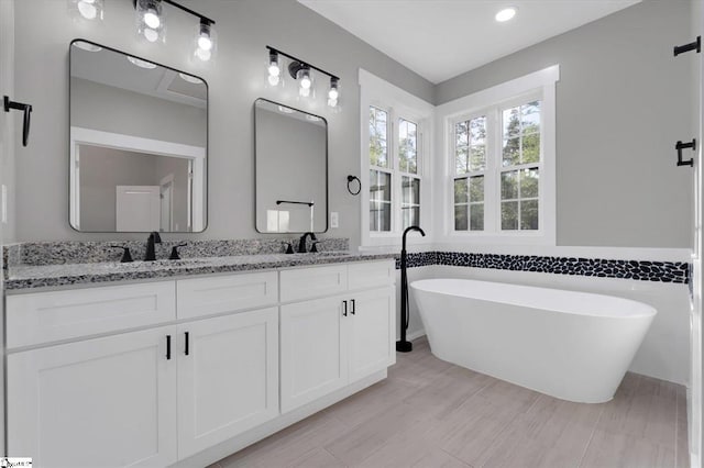 bathroom with a tub to relax in and vanity