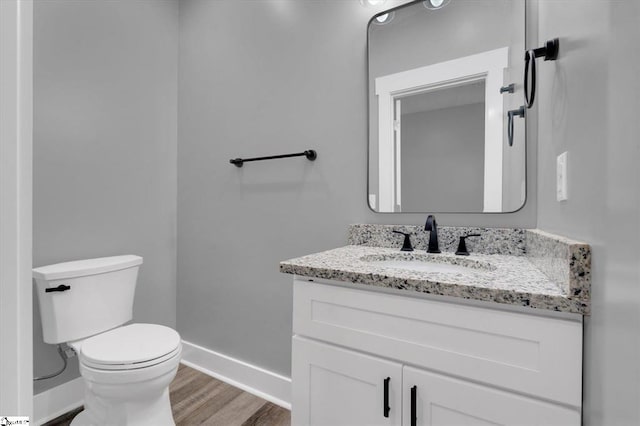 bathroom with vanity, hardwood / wood-style flooring, and toilet