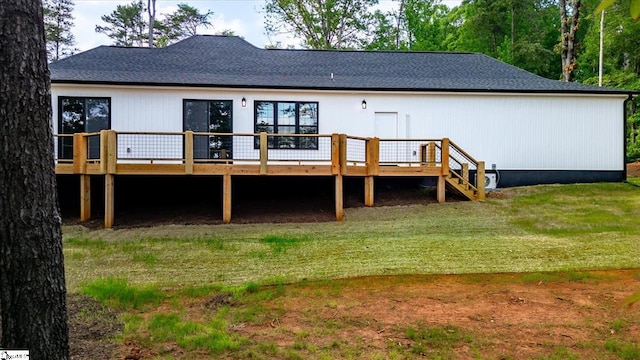 back of property featuring a lawn and a deck