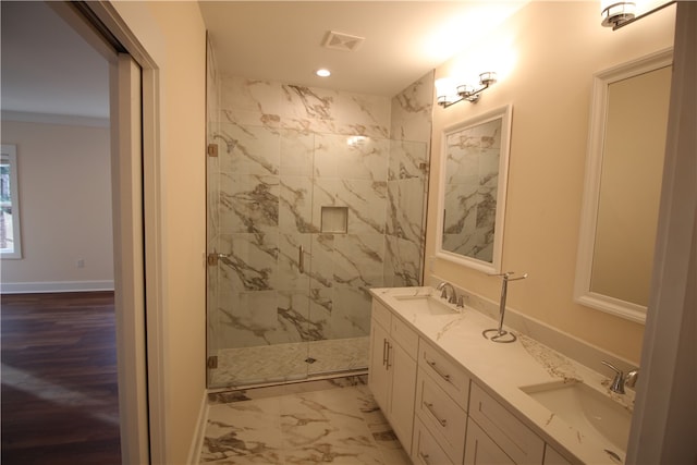 bathroom with vanity, a shower with door, and crown molding