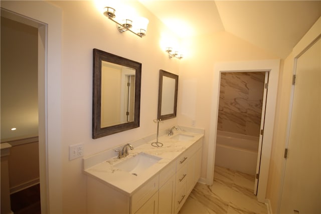 bathroom featuring vanity, lofted ceiling, and a bath