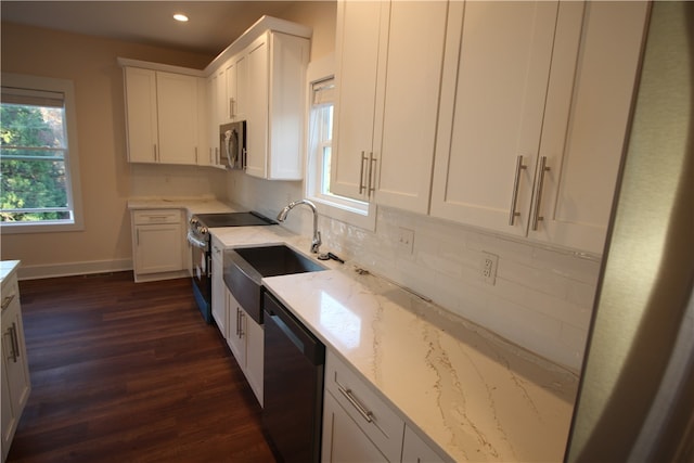 kitchen featuring white cabinets, sink, light stone countertops, appliances with stainless steel finishes, and dark hardwood / wood-style flooring