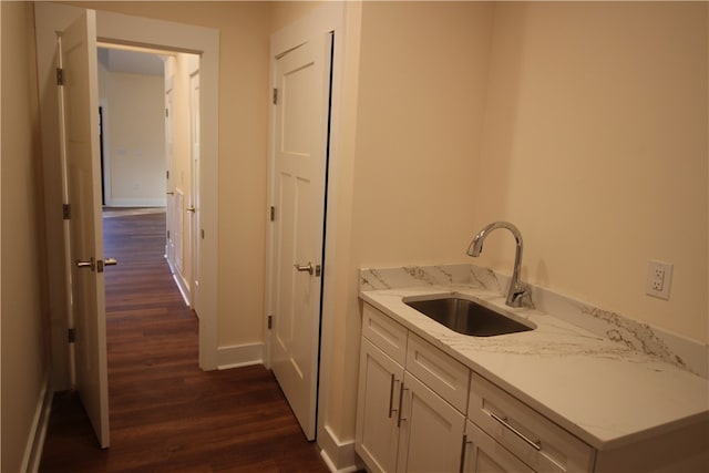 clothes washing area featuring dark hardwood / wood-style floors and sink