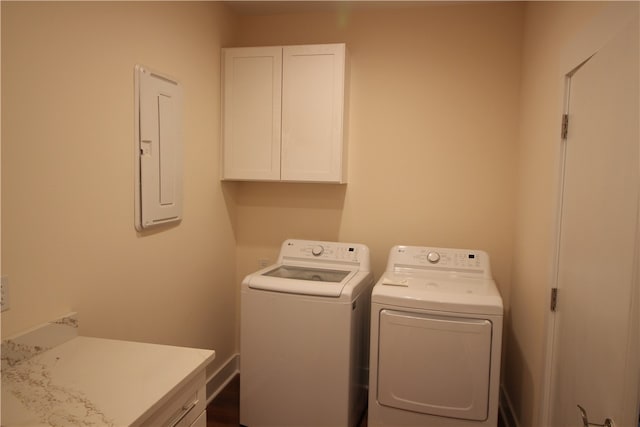 laundry area featuring washing machine and clothes dryer, electric panel, and cabinets