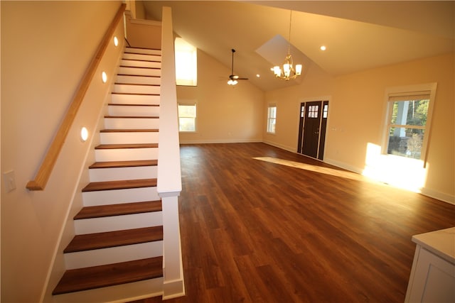 unfurnished living room featuring high vaulted ceiling, dark wood-type flooring, and ceiling fan with notable chandelier