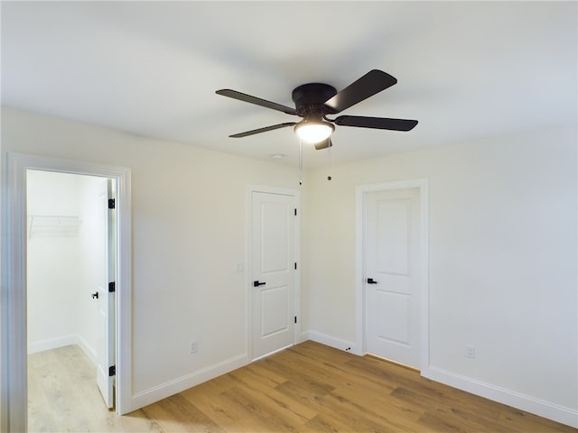 unfurnished bedroom featuring ceiling fan, light hardwood / wood-style floors, and a closet