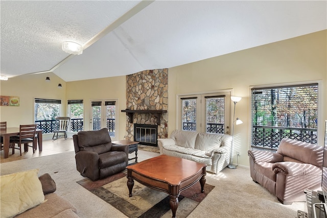 carpeted living room with a stone fireplace, a textured ceiling, and high vaulted ceiling