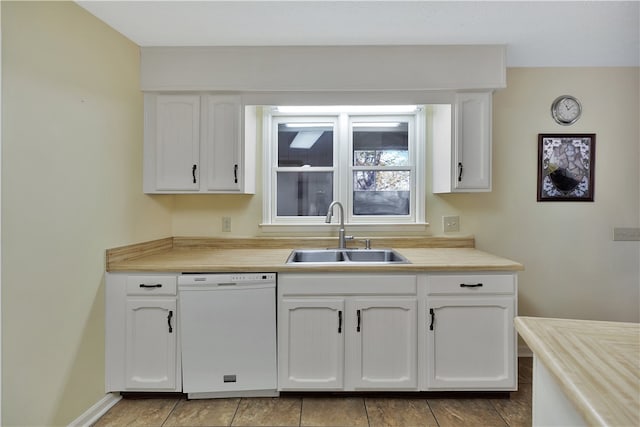 kitchen featuring dishwasher, white cabinets, light tile patterned floors, and sink