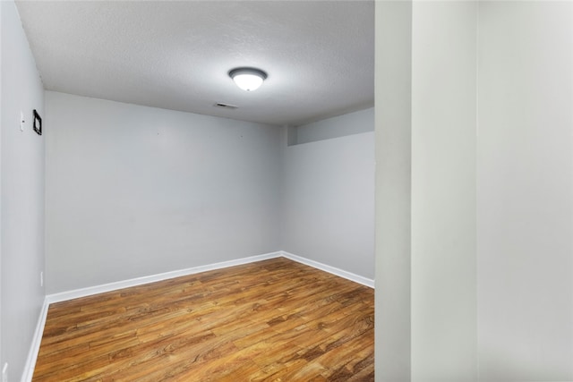 empty room with hardwood / wood-style flooring and a textured ceiling