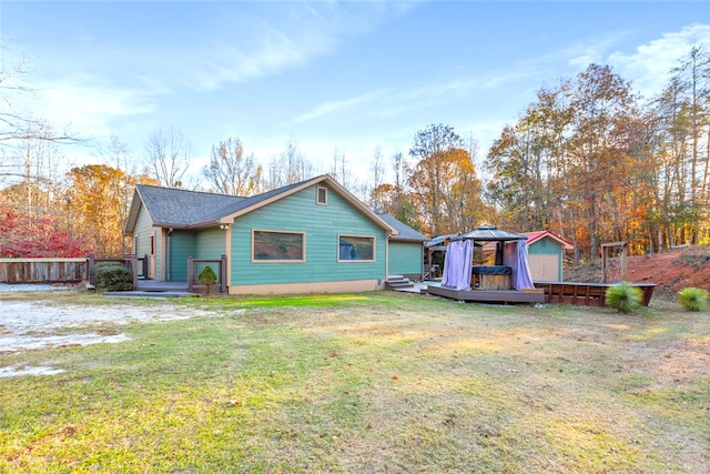 back of house featuring a gazebo, a lawn, and a wooden deck