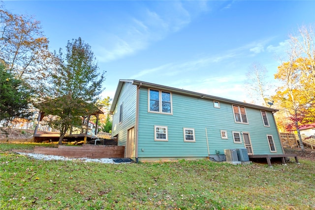 back of house with central AC and a yard