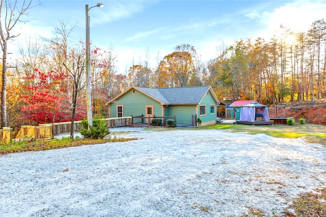 view of front of home with a wooden deck and a storage shed