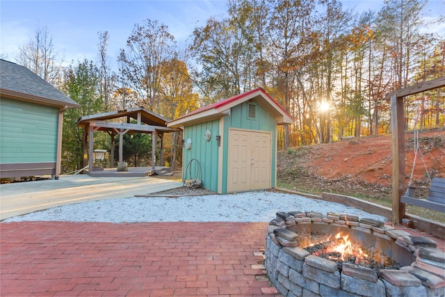 exterior space featuring a fire pit, a gazebo, and a storage shed