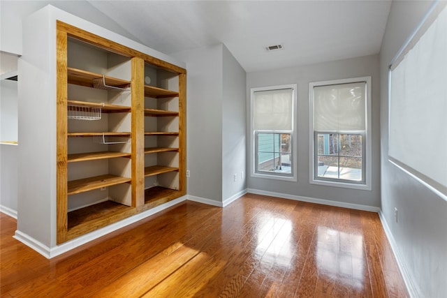 interior space featuring hardwood / wood-style floors and vaulted ceiling