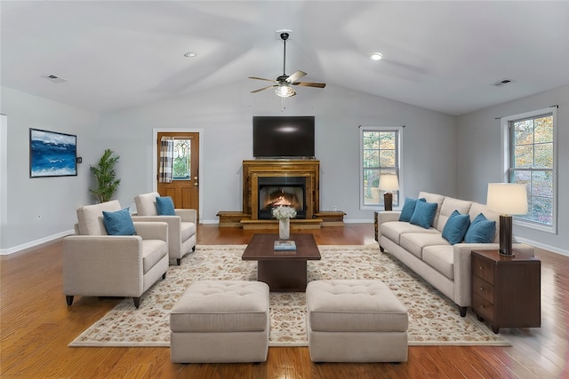 living room featuring wood-type flooring, vaulted ceiling, a wealth of natural light, and ceiling fan