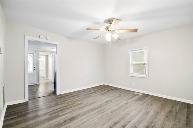 empty room with ceiling fan and dark wood-type flooring