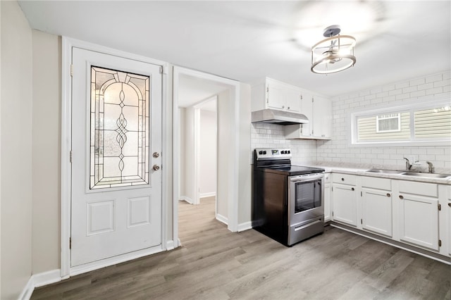 kitchen with stainless steel range with electric stovetop, light hardwood / wood-style floors, white cabinetry, and sink