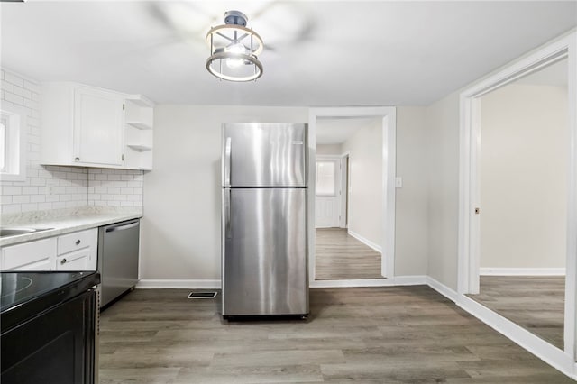 kitchen with light hardwood / wood-style floors, white cabinetry, and appliances with stainless steel finishes