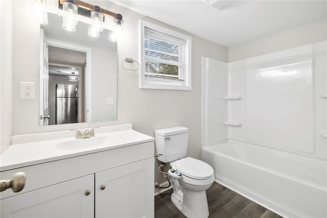 full bathroom featuring vanity, toilet, wood-type flooring, and bathing tub / shower combination