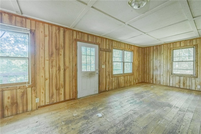 interior space featuring wooden walls, plenty of natural light, wood-type flooring, and coffered ceiling