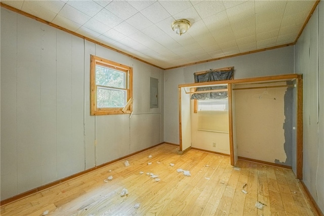 unfurnished bedroom featuring electric panel, light hardwood / wood-style floors, and ornamental molding