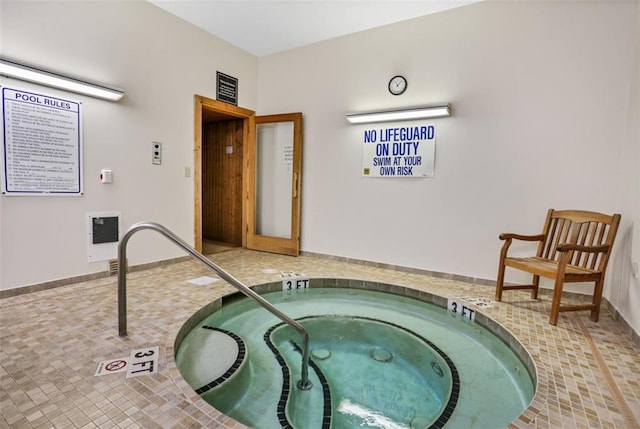 view of swimming pool with an indoor hot tub