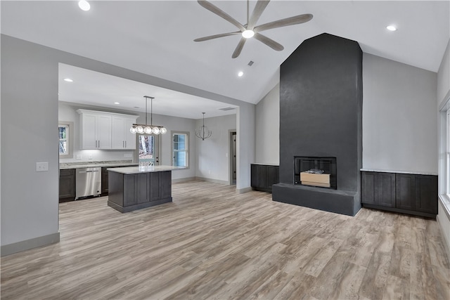 kitchen with a center island, hanging light fixtures, stainless steel dishwasher, white cabinets, and light wood-type flooring